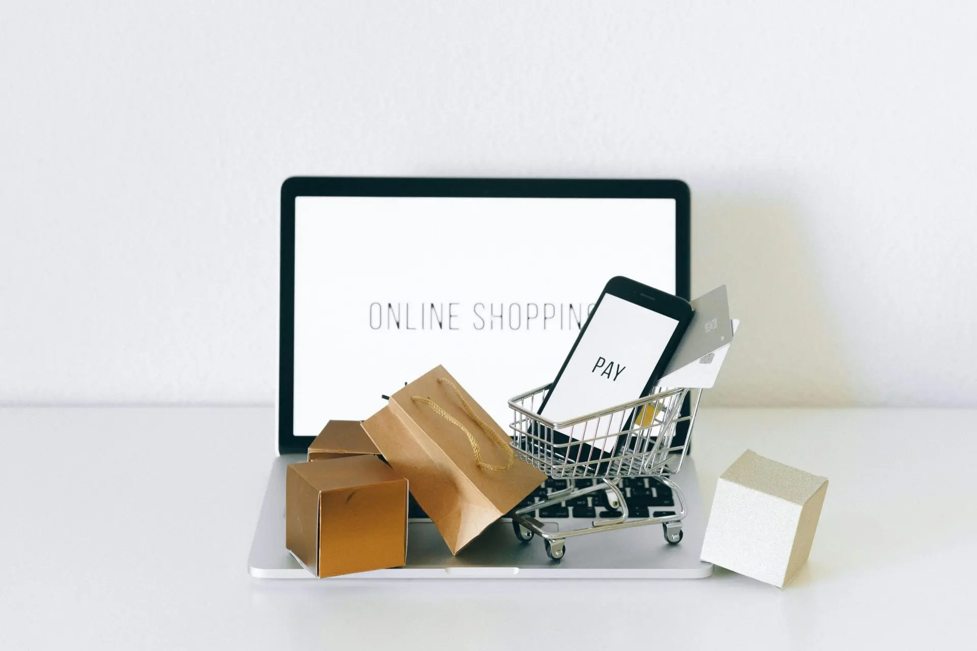 Costi e-commerce 2025 A miniature shopping cart on macbook laptop